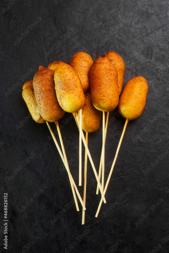 Corn dogs cooked with sausage and dough, black background top view - obrazy, fototapety, plakaty 