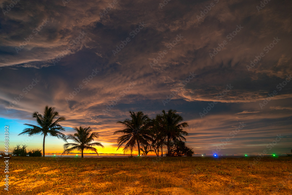 scenery sunset above coconut trees during colorful .cloud in sunset on Karon beach Phuket Thailand. .Scene of Colorful red light in the sky background.