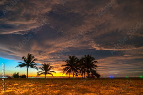 scenery sunset above coconut trees during colorful .cloud in sunset on Karon beach Phuket Thailand. .Scene of Colorful red light in the sky background.