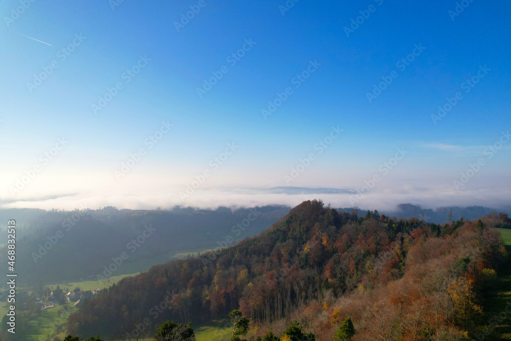 Aerial perspective of autumn landscape with sea of fog at region of Uetliberg Albis at Canton Zürich on a beautiful sunny day. Photo taken November 12th, 2021, Zurich, Switzerland.