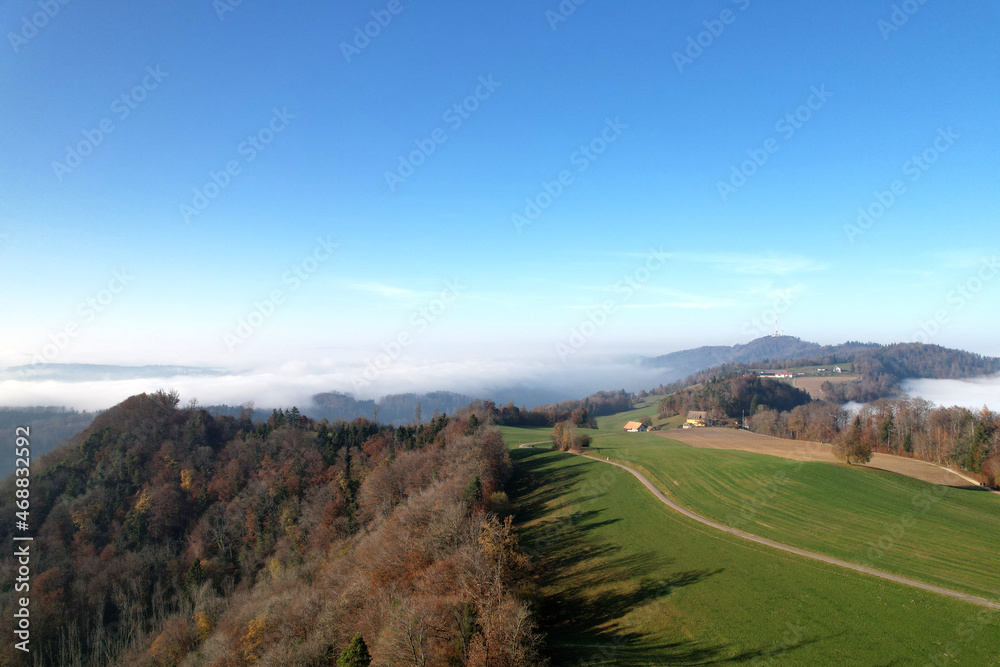 Aerial perspective of autumn landscape with sea of fog at region of Uetliberg Albis at Canton Zürich on a beautiful sunny day. Photo taken November 12th, 2021, Zurich, Switzerland.