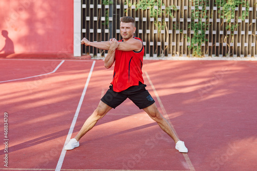 athletic man in red jersey on the sports ground exercise © VICHIZH
