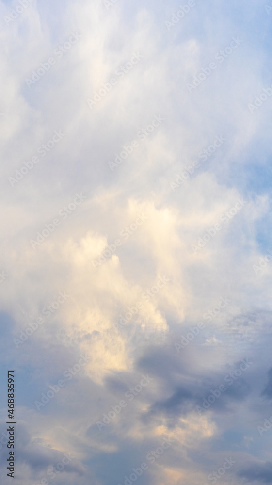 Obraz premium Bright sky with white and blue clouds, vertical format