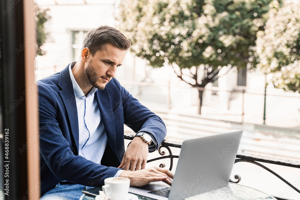 Programmer with cup of coffee is working online using laptop in cafe. Remote work. Programmer with cup of coffee is working online using laptop in cafe. Remote work.
