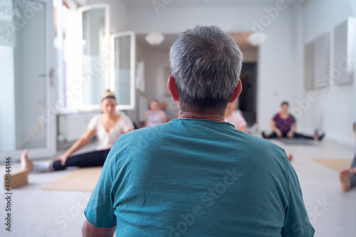 Εκτύπωση καμβά View from behind, of an instructor, with white hair, during a yoga class