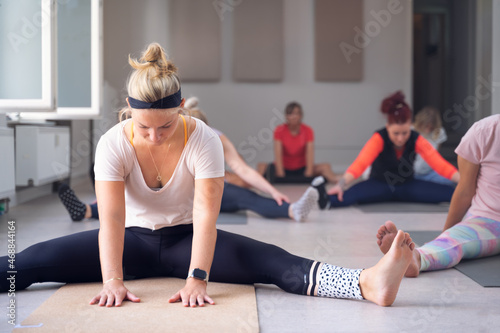 Women of different ages, doing stretches during a yoga class.