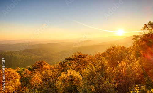 Sunrise in November over scenic mountaintop in Ouachita National Forest  with fall colors  heavy mist and fog in valleys  and sun flares