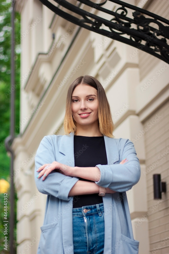 Portrait of a successful happy girl on the background of an architectural building. Business style. Confident business woman Portrait of a successful happy girl on the background of an architectural building. Business style. Confident business woman