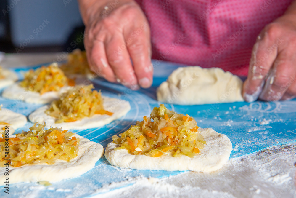 grandmother makes pies with cabbage from dough. High quality photo