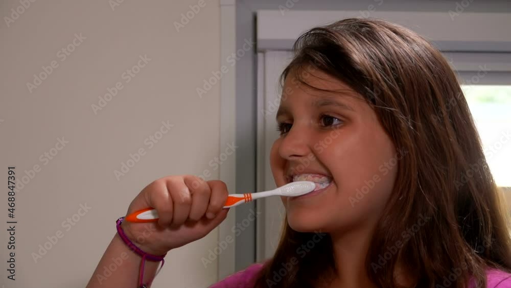 Close-up of the beautiful tanned girl brushes her teeth carefully in a bathroom Close-up of the beautiful tanned girl brushes her teeth carefully in a bathroom