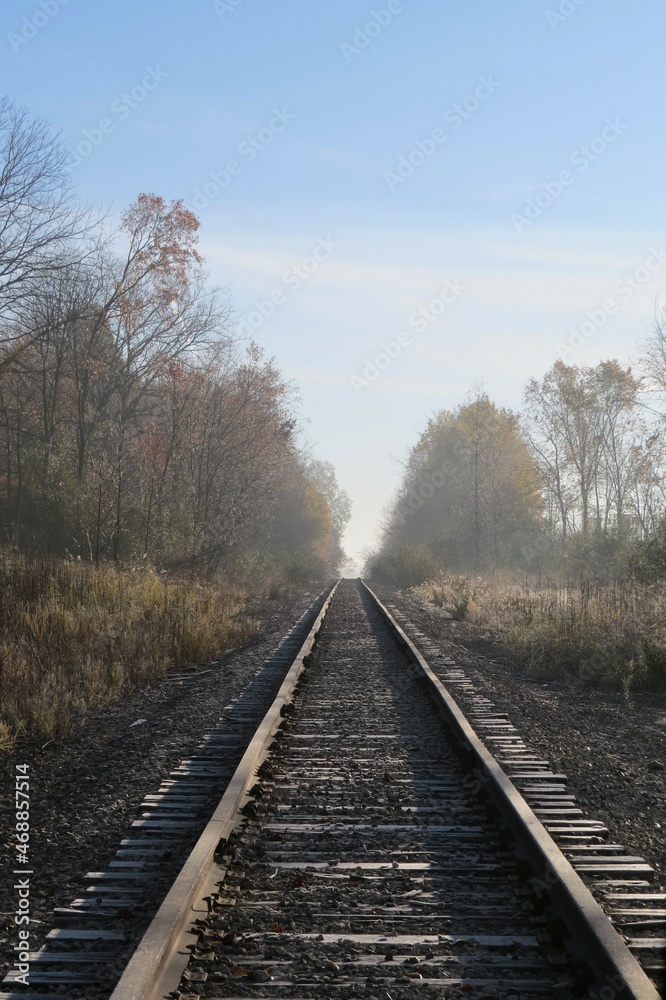 View Down Railroad Tracks Disappearing into Foggy Hazy Horizon View Down Railroad Tracks Disappearing into Foggy Hazy Horizon