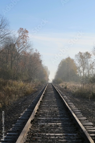 View Down Railroad Tracks Disappearing into Foggy Hazy Horizon 