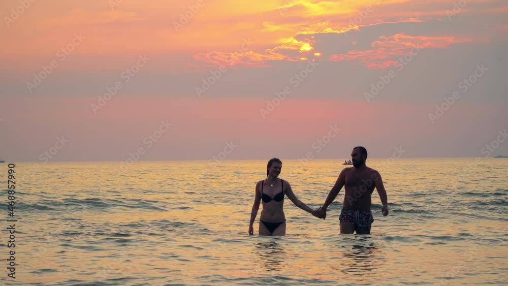Young lovers having tender moments in the sea at sunset on romantic summer vacation. Love concept Young lovers having tender moments in the sea at sunset on romantic summer vacation. Love concept