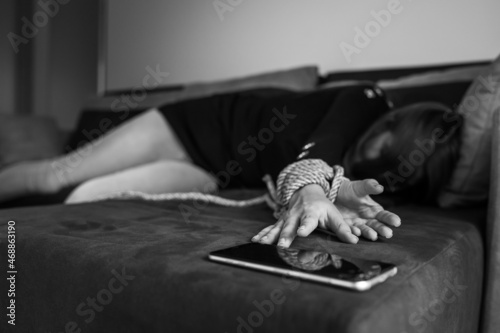 Photography Unknown caucasian woman victim of human trafficking reaching for her mobile phon