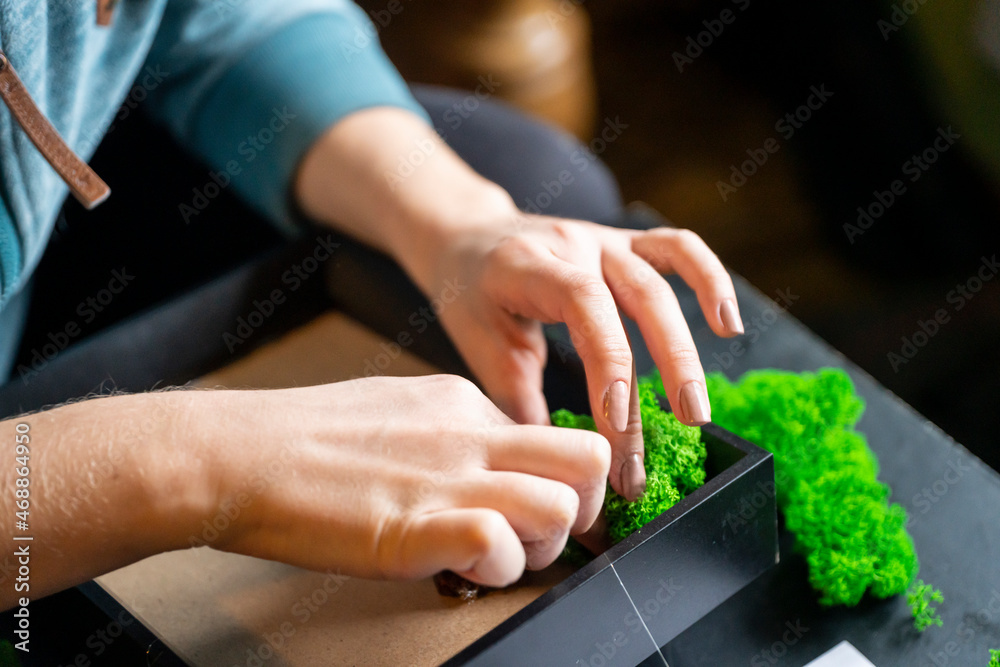 Obraz na płótnie Damskie dłonie tworzące obraz z mchem / Women's hands creating an image with moss w salonie