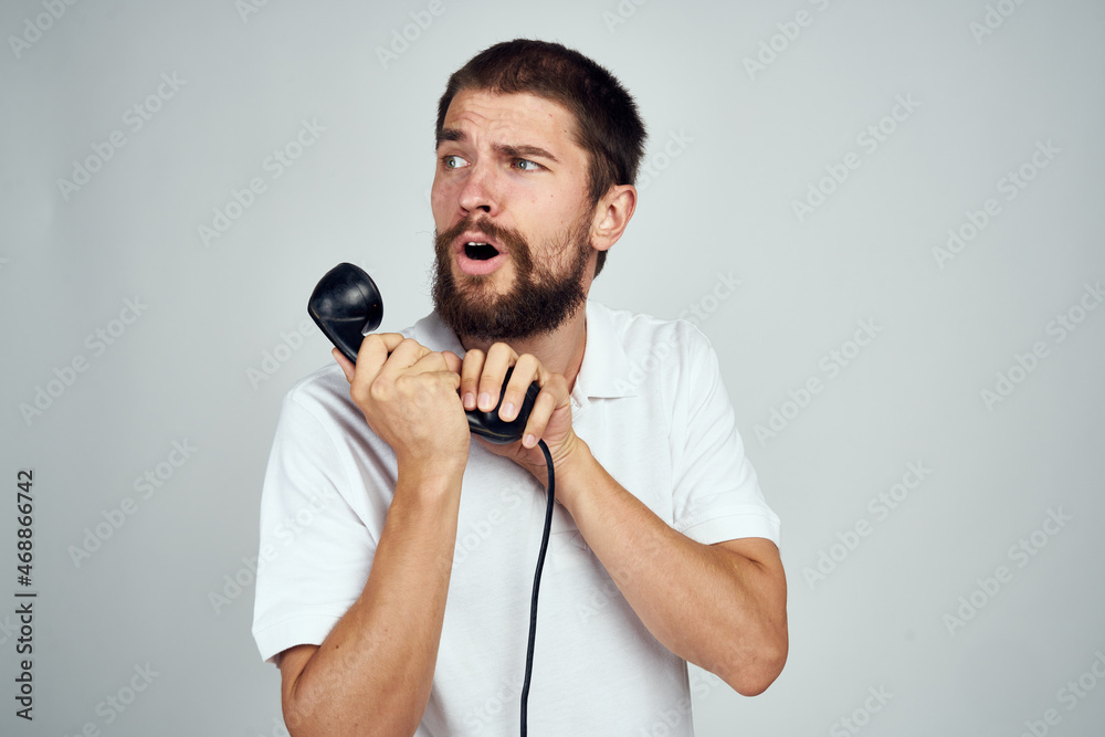 man with home phone in hands technology light background emotions man with home phone in hands technology light background emotions