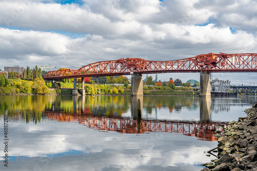 Broadway drawbridge over the Willamette River in Portland with water reflection and autumn trees photo
