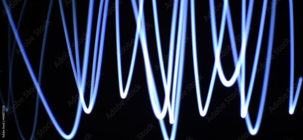 Abstract concept of Neon Blue wave pattern abstract Streaming through the isolated black background with copy space made using Light photography technique called Light painting. Light trails.