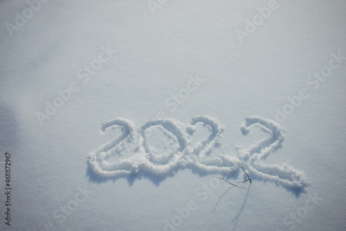 Drawing on white snow. New Year's date, figures 2022, close-up.