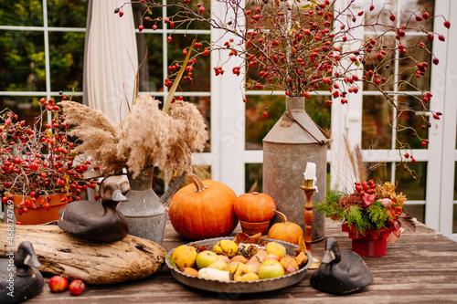 wooden table in the backyard of the house decorated in autumn style. 