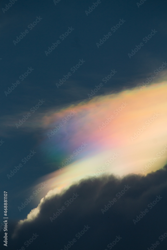 Bright rainbow cloud formed above some high white clouds.