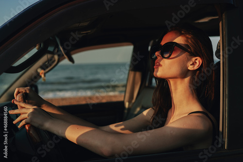 cheerful woman in sunglasses driving a car trip travel © VICHIZH