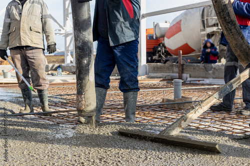 фотографія A construction worker is finishing and leveling the concrete surface of the foundation at a construction site