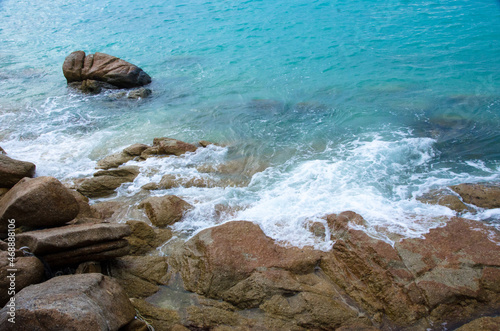 Waves crushing into the rocks. Bubble sea waves hit the rocks. (Koh Lipe, Thailand) © konjaunt