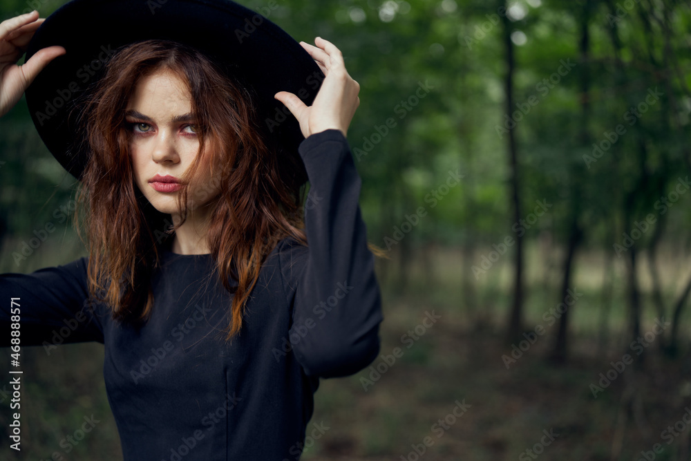 woman in black dress in the forest Halloween Witch costume woman in black dress in the forest Halloween Witch costume