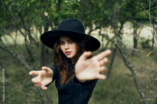 woman in a black hat gesturing with her hands witch magic fantasy