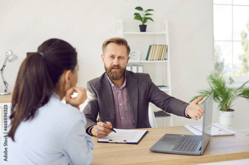 Male manager provides advice to female client and acquaints her with terms of contract. Businessman, hr employee, banker, financial advisor, realtor or lawyer pointing at screen during consultation. Male manager provides advice to female client and acquaints her with terms of contract. Businessman, hr employee, banker, financial advisor, realtor or lawyer pointing at screen during consultation.