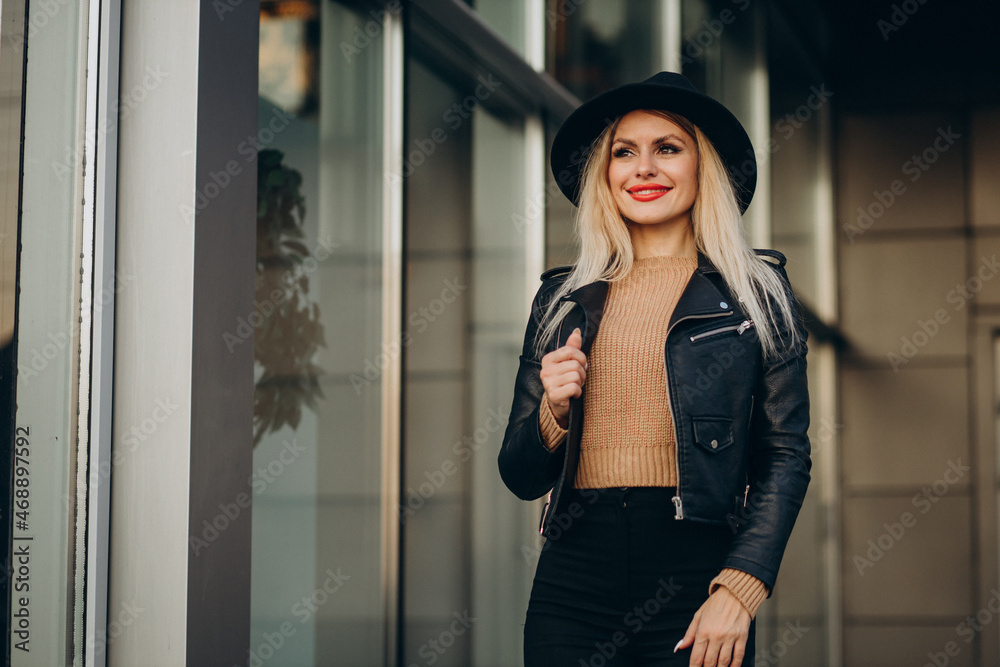 Young woman in black hat walking outside the street