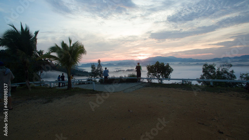 aerial view scenery sunrise mist above the mountain in tropical rainforest..slow floating fog blowing cover on the top of mountain look like as a sea of mist. .beautiful sunrise in the mist background