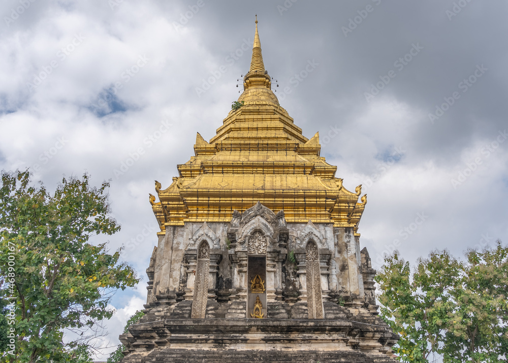 Low angle landscape view of beautiful golden stupa at ancient landmark Wat Chiang Man, the oldest buddhist temple in Chiang Mai, Thailand