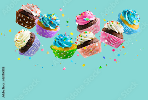 Fototapeta Cupcakes with colorful sprinkles falling over aqua blue background