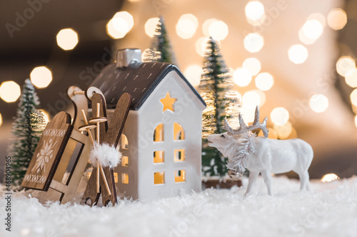 Happy New Year 2022. Beautiful background with a house, snow, deer and Christmas trees in Scandinavian style. Celebrating the winter Christmas holidays. The concept of the beginning of the yea