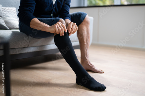 Man Putting On Medical Compression Stockings photo