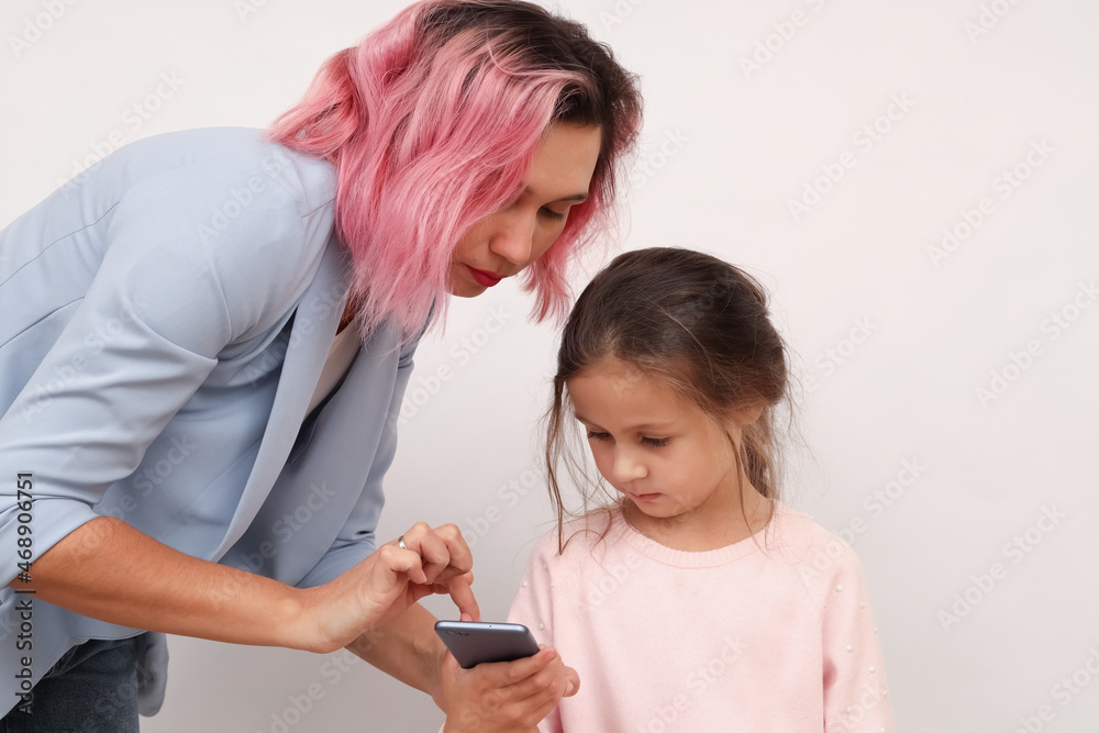 A business mom in a suit helps her daughter figure out smartphone apps A business mom in a suit helps her daughter figure out smartphone apps