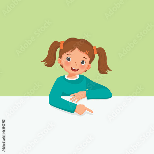 little girl standing behind blank board peeking and pointing to empty banner with finger