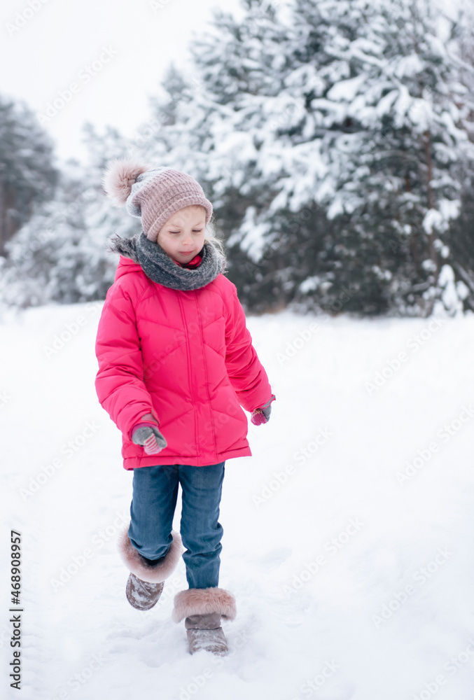 Little girl in a bright jacket plays in the winter forest Little girl in a bright jacket plays in the winter forest