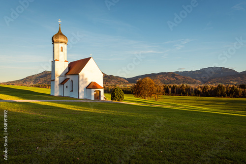 Die Kapelle St. Johann oberhalb des Loisachtals, dem Kochelsee und den herbstlichen bayrischen Voralpen in der Abendsonne, Deutschland photo
