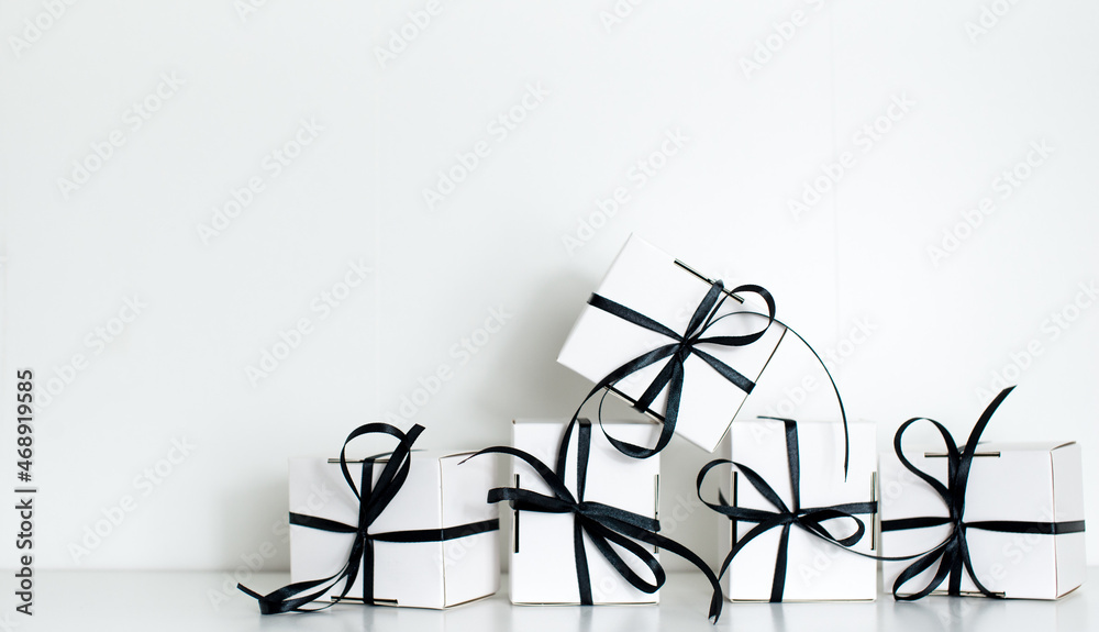 Black Friday sale with stylish gift box present and black ribbon on white background, flat lay, top view, copy space. Black friday concept. Shopping concept and black Friday composition. Black Friday sale with stylish gift box present and black ribbon on white background, flat lay, top view, copy space. Black friday concept. Shopping concept and black Friday composition.