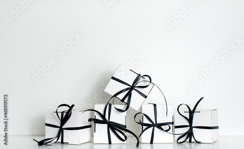 Black Friday sale with stylish gift box present and black ribbon on white background, flat lay, top view, copy space. Black friday concept. Shopping concept and black Friday composition.
