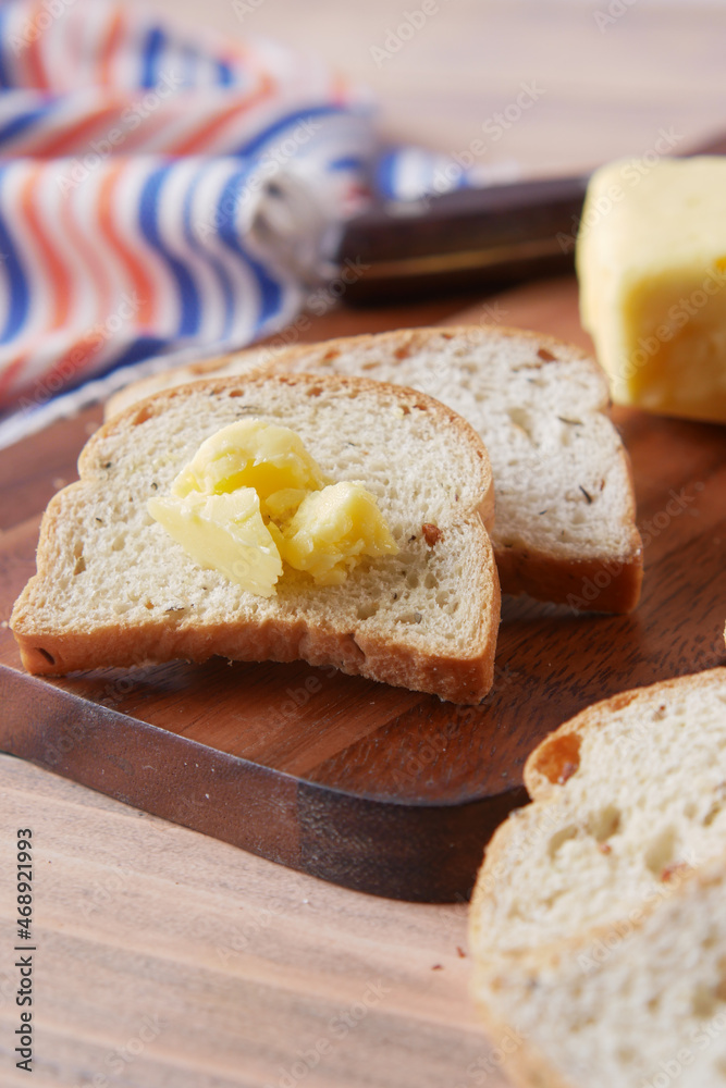 slice of butter and whole meal bread on chopping board slice of butter and whole meal bread on chopping board