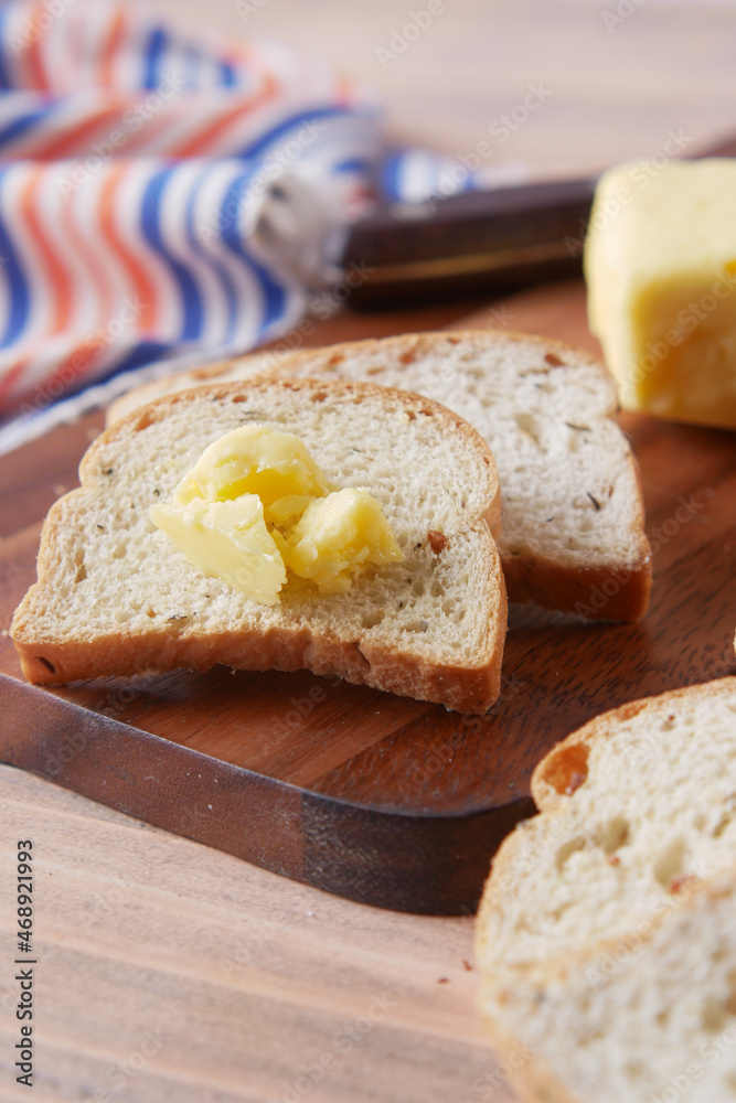 slice of butter and whole meal bread on chopping board 