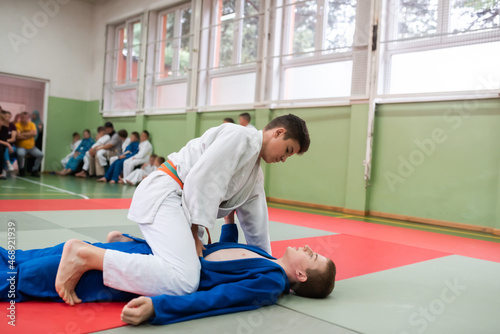 Two judo fighters showing technical skill while practicing martial arts in a fight club. The two fit men in uniform. fight, karate, training, arts, athlete, competition concept.Selective Focus © Minet