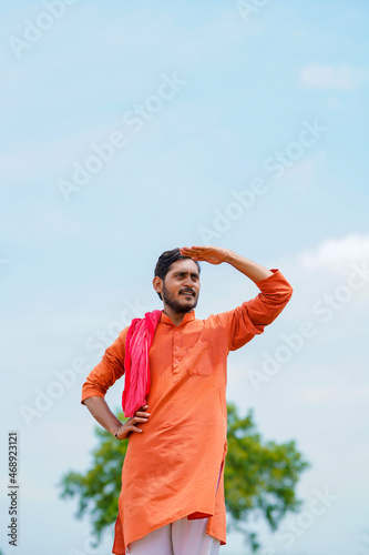 Indian farmer standing on bricks and watching on sky