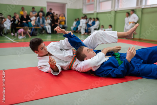 Two judo fighters showing technical skill while practicing martial arts in a fight club. The two fit men in uniform. fight, karate, training, arts, athlete, competition concept.Selective Focus photo