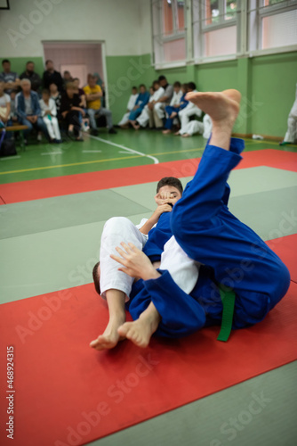 Two judo fighters showing technical skill while practicing martial arts in a fight club. The two fit men in uniform. fight, karate, training, arts, athlete, competition concept.Selective Focus photo