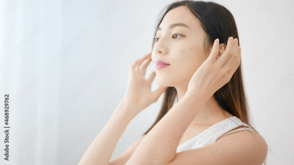 ヘアケアをする若い女性 ヘアケアをする若い女性
